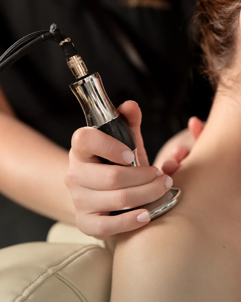 A Purelux therapist using a care device on a guest's neck